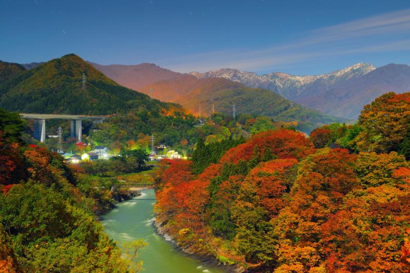 [ 諏訪峡の紅葉と谷川岳 ]  紅葉と月明かりが重なり、真夜中の諏訪峡は色鮮やかな絶景に。谷川岳の上空を雲が流れていきました。