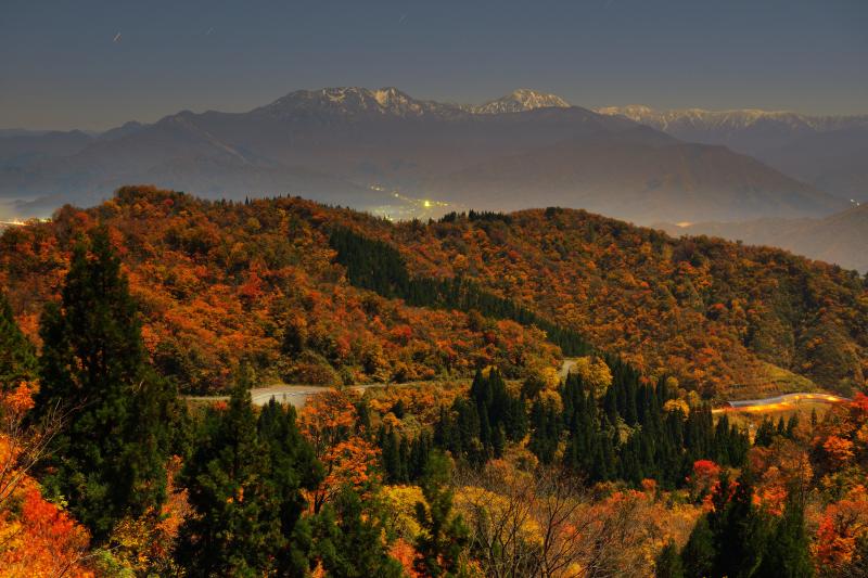 [ 錦秋スカイライン ]  紅葉ピークの魚沼スカイライン。奥には冠雪した八海山を望むことができました。