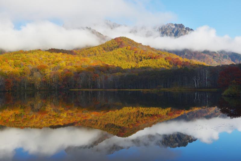 [ 紅葉シンメトリー ]  紅葉の木々と空そして流れ行く雲が鏡のように水面に映り込んでいました。