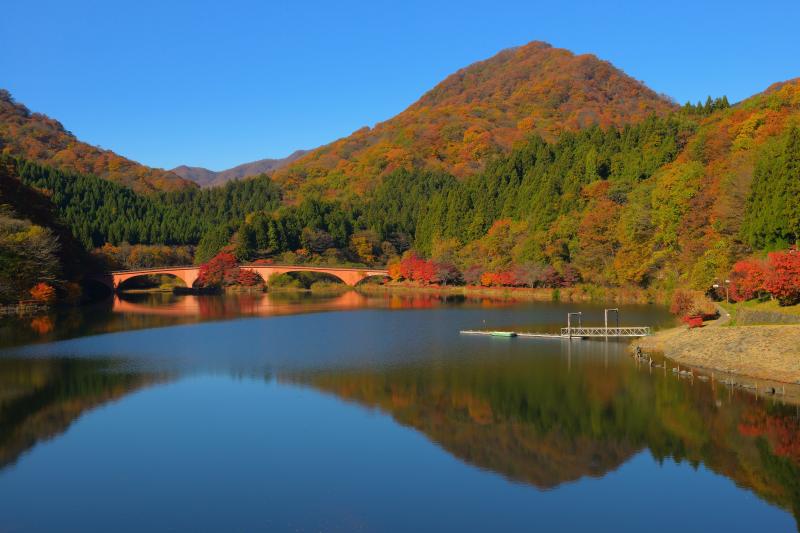 [ 紅葉の山々と碓氷湖 ]  対岸にはレンガ調の橋があり、歴史を感じる湖になっています。めがね橋はこのすぐ上側にあります。