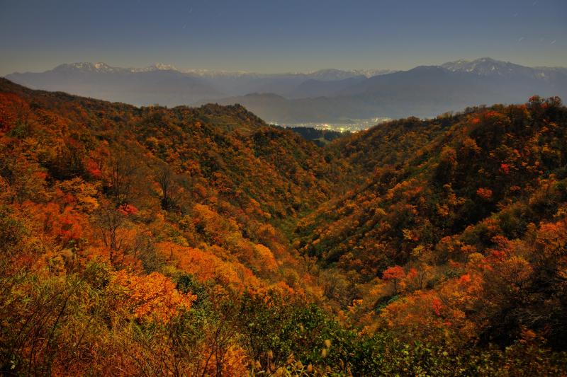 [ 紅葉谷 ]  深い谷を埋め尽くす紅葉。魚沼の街明かりと初冠雪した越後の峰々の絶景が広がっていました。