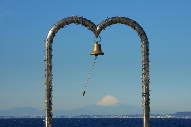 幸せの鐘と富士| 海岸沿いの駐車場にある幸せの鐘。フレームの中に富士山を入れることができ、観光スポットとして人気の場所です。