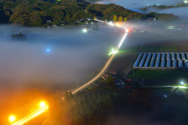 [ 雲海レーザービーム ]  早朝に雲海が湧き始め、その中を走る車の光跡が幻想的でした。夜明け前は雲海と街明かり、車の光跡のコラボレーションや星撮影を楽しむことができます。