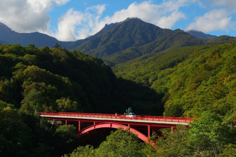 [ 赤い橋と八ヶ岳 ]  初秋の東沢大橋と八ヶ岳。青い空にモクモクと雲が湧いてきました。