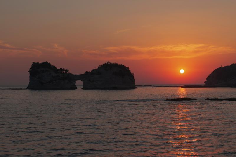 円月島夕日| 円月島の奥に夕日が静かに沈んでいきました。