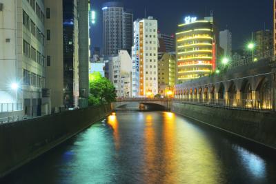 夜のライトを映す神田川。奥は秋葉原の街です。