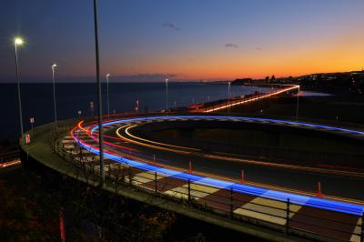 ループ橋夕景| ループ橋を青いLEDで装飾されたトラックが走り抜けていきました。マジックアワーの空と光跡の絶景ポイント。