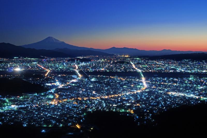 静岡の夜景と富士山| 夜明け前、空が色を取り戻す頃に冠雪した富士山が見えてきました。