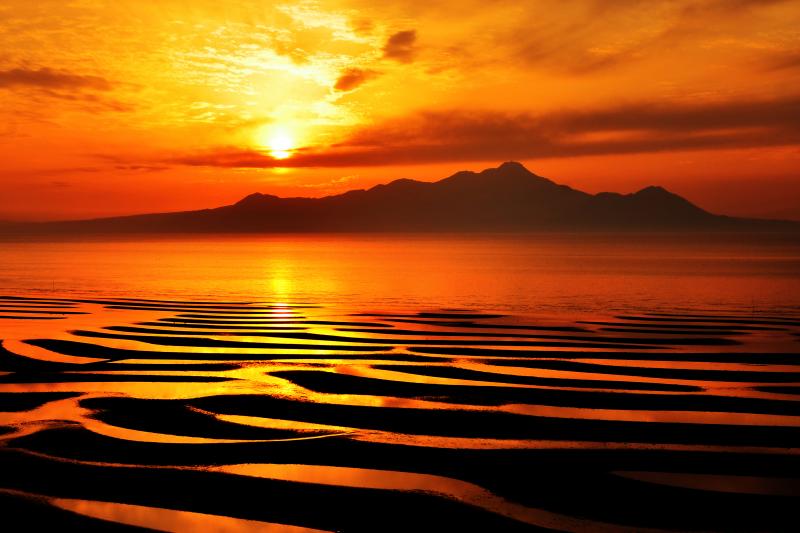 [ 御輿来海岸夕景 ]  干潟模様が非常に美しい。背景は雲仙普賢岳。夕日が干潟模様を印象的に染め上げていました。
