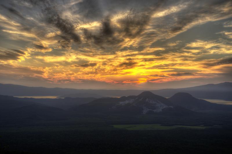 [ 夕刻の硫黄山 ]  摩周湖第三展望台から見た夕刻の硫黄山。後ろに屈斜路湖が見えます。西から迫ってくる雲が印象的でした。