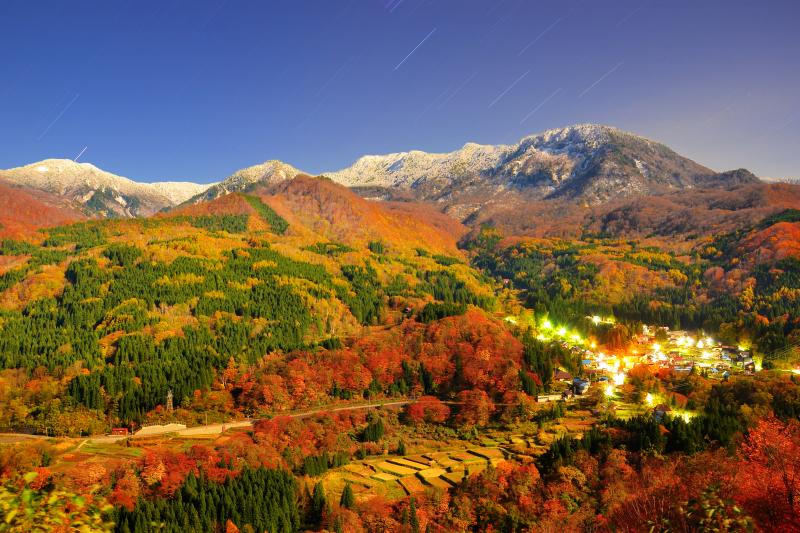 月夜の冠雪| 月明かりに照らされた苗場山と秋山郷の集落の灯りが幻想的。