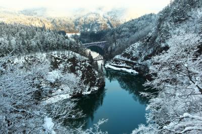 静かな川面に映り込む第一只見川橋梁。奥の山に光が差し込み、眩しいほどに輝いていました。