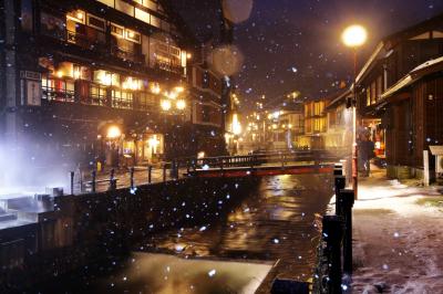 雪降る温泉街| 銀山温泉のメインストリート。風情ある旅館が川の両側に並んでいます。