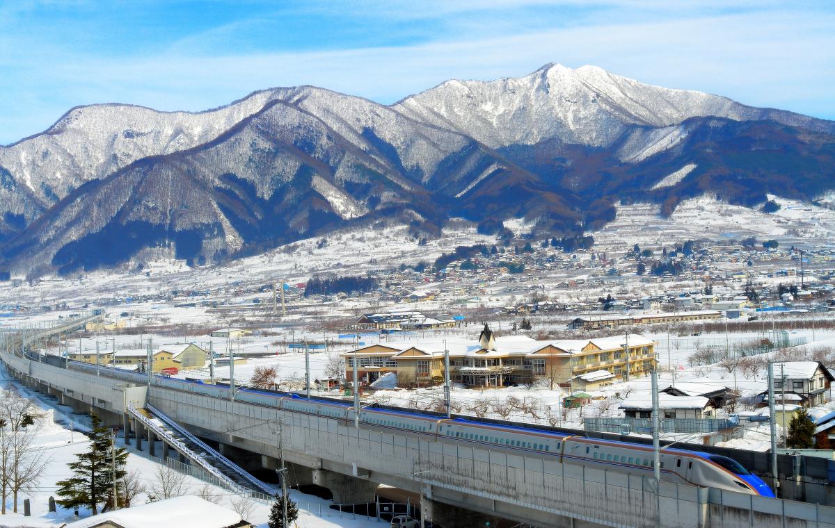 高丘トンネル 冬景色の中を駆け抜ける北陸新幹線と高社山