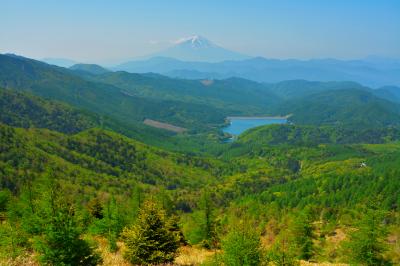 大菩薩嶺からの富士山の眺望。なだらかな斜面には緑の美しいグラデーションが広がり、その中に上日川ダムの姿が。