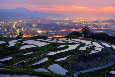 姨捨棚田朝焼け| 夜があける頃、紅く染まる朝焼けと善光寺平の夜景を見ることができます。